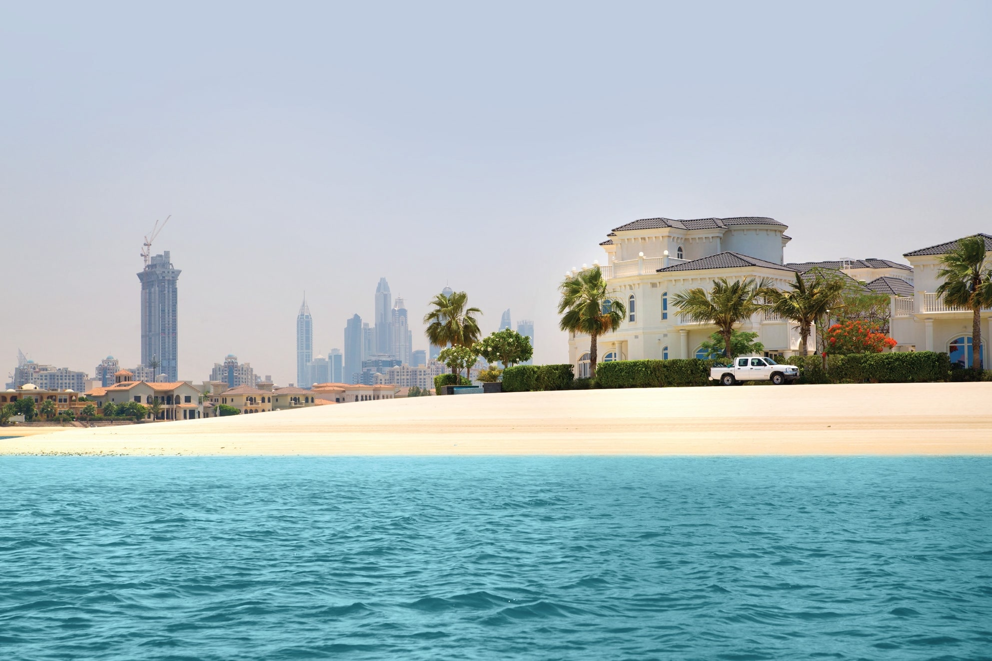 Beachfront villa with Dubai skyline.