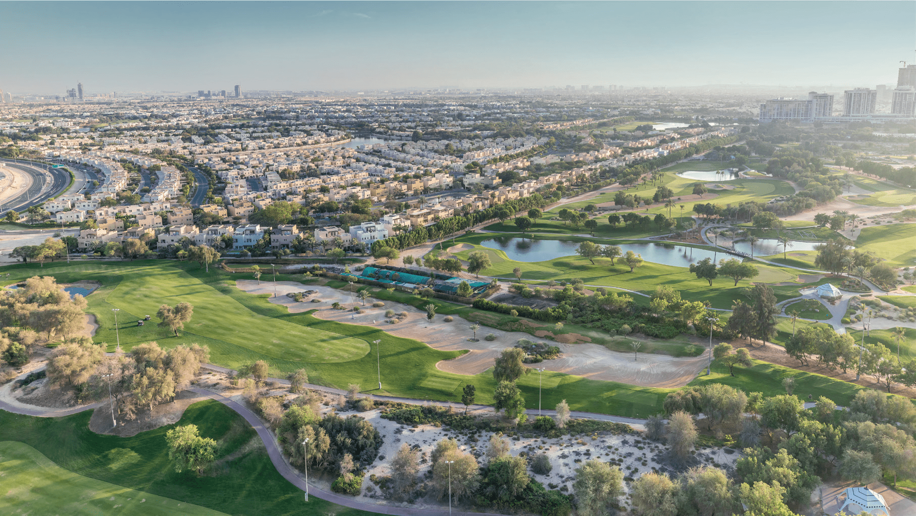 An aerial view of a residential community built around a green golf course.